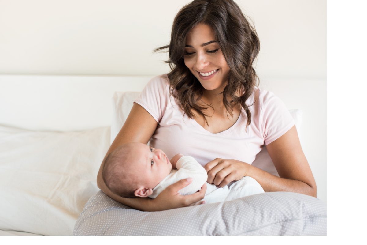 Femme utilisant un coussin d'allaitement bébé